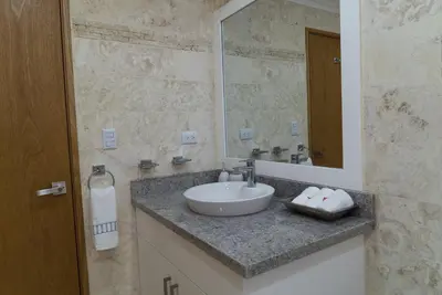 a bathroom with a sink and a mirror at 3BR / 3BA Modern Paradise Loft Condo in Gated Community w/ Daily Housekeeping in Sosúa