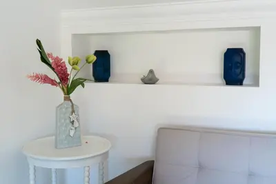 a vase with flowers on a table next to a couch at 3BR / 3BA Modern Paradise Loft Condo in Gated Community w/ Daily Housekeeping in Sosúa