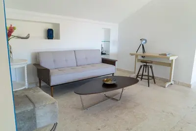 a living room with a couch and a table at 3BR / 3BA Modern Paradise Loft Condo in Gated Community w/ Daily Housekeeping in Sosúa