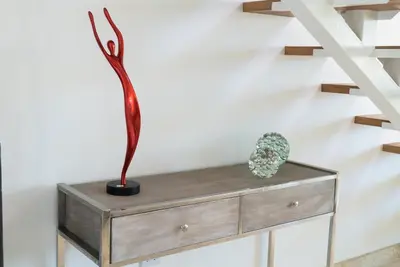 a wooden dresser with a vase on top of it at 3BR / 3BA Modern Paradise Loft Condo in Gated Community w/ Daily Housekeeping in Sosúa