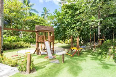 a playground in a garden with a wooden structure at Apartment in Sublime Samana Résidence in Las Terrenas