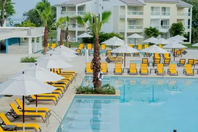 a swimming pool with chairs and umbrellas and a hotel at Emotions by Hodelpa Puerto Plata in San Felipe de Puerto Plata