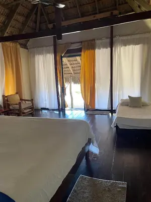 a bedroom with two beds in a room with curtains at Playa Paraiso en Magante in La Yagua