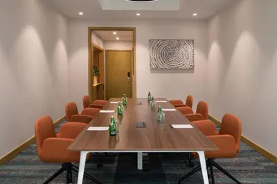 a conference room with a long table and orange chairs at Courtyard by Marriott Santo Domingo in Santo Domingo