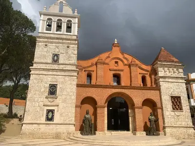 a large brick building with a clock tower at Hotel Cana Palma Zona Colonial in Santo Domingo