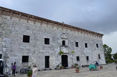 a large stone building with people standing in front of it at Hotel Cana Palma Zona Colonial in Santo Domingo