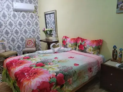 a bedroom with a bed with a floral bedspread at Hotel Cana Palma Zona Colonial in Santo Domingo