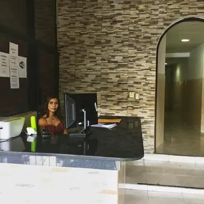 a woman sitting at a desk with a computer at Caribbean Hotel Santo Domingo in Santo Domingo