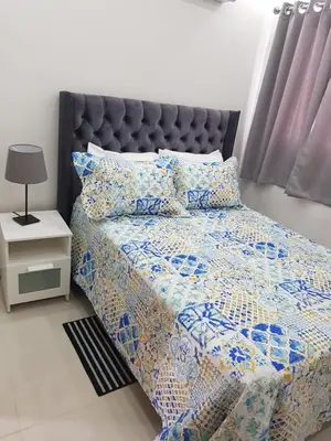 a bedroom with a bed with a blue and white quilt at KSL Residence in Boca Chica