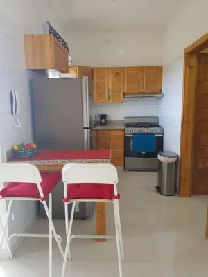 a kitchen with a table and two chairs and a refrigerator at KSL Residence in Boca Chica