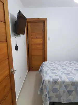 a bedroom with a bed and a flat screen tv at KSL Residence in Boca Chica