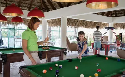 a woman and a child playing pool in a room at Royalton Bavaro, An Autograph Collection All-Inclusive Resort & Casino in Punta Cana