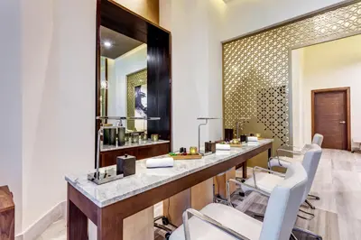 a vanity with white chairs and a mirror at Royalton Bavaro, An Autograph Collection All-Inclusive Resort & Casino in Punta Cana