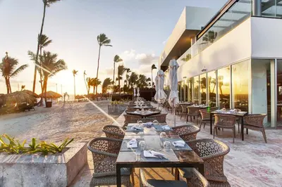 a restaurant on the beach with tables and chairs at Royalton Bavaro, An Autograph Collection All-Inclusive Resort & Casino in Punta Cana