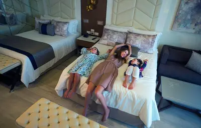 a woman and two children laying on a bed at Royalton Bavaro, An Autograph Collection All-Inclusive Resort & Casino in Punta Cana