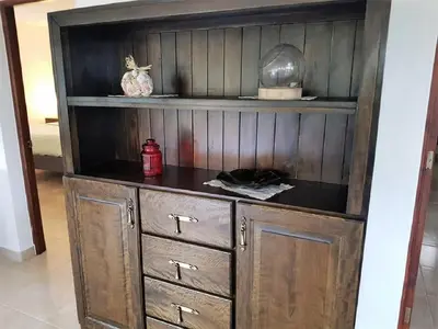 a wooden cabinet with a shelf and a red appliance at Luxury apartment with ocean view at the beach in Cabarete