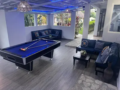 a pool table in a living room with couches at Diamond Hotel Cabarete in Cabarete