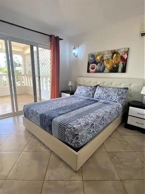 a bedroom with a bed and a painting on the wall at Diamond Hotel Cabarete in Cabarete