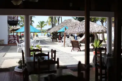 a patio with tables and chairs and umbrellas at Hotel Zapata in Boca Chica