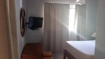 a bedroom with a bed and a tv and a window at Hotel Zapata in Boca Chica