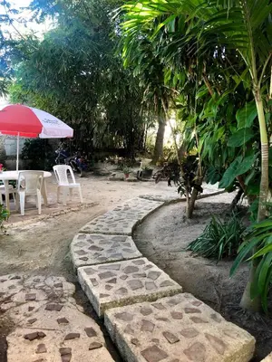 a stone walkway with a table and chairs and an umbrella at Villa Florencia Bavaro in Punta Cana