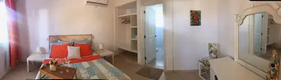 a small room with a bed and a mirror at Villa Florencia Bavaro in Punta Cana