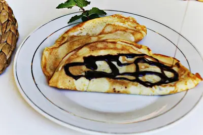 a white plate with a sandwich with chocolate sauce at Hotel Pedernales Italia Republica Dominicana in Pedernales