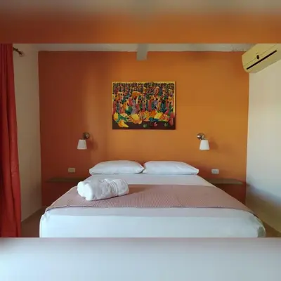 a bedroom with a bed with a painting on the wall at Hotel Pedernales Italia Republica Dominicana in Pedernales