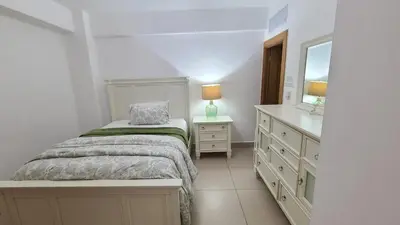 a bedroom with a bed and a dresser and a mirror at Las Olas by Destinos1a in Juan Dolio