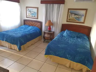 a bedroom with two beds and a tiled floor at Villa M-6 Metro Country Club in Juan Dolio