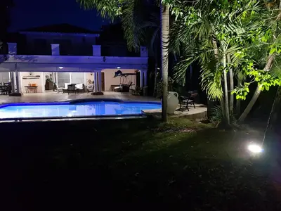 a house with a swimming pool at night at Villa M-6 Metro Country Club in Juan Dolio