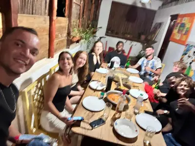 a group of people sitting around a table at Hostel La Ballena Backpacker in Las Galeras