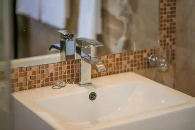a bathroom sink with a faucet and a mirror at Caribbean Diamond Boutique Hotel in Sosúa