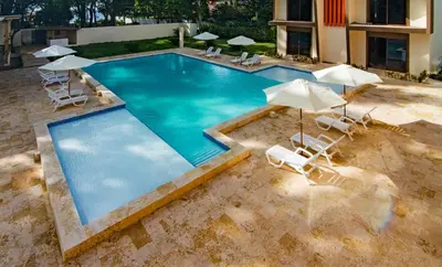 an overhead view of a swimming pool with chairs and umbrellas at Caribbean Diamond Boutique Hotel in Sosúa