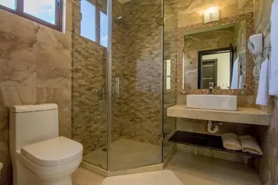 a bathroom with a shower and a toilet and a sink at Caribbean Diamond Boutique Hotel in Sosúa