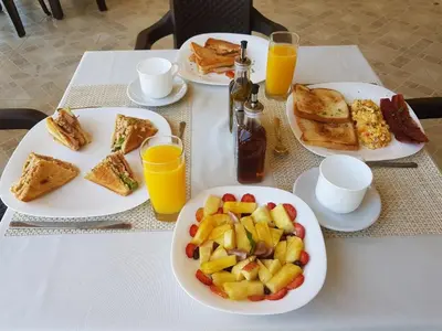 a table with plates of breakfast food on it at Caribbean Diamond Boutique Hotel in Sosúa