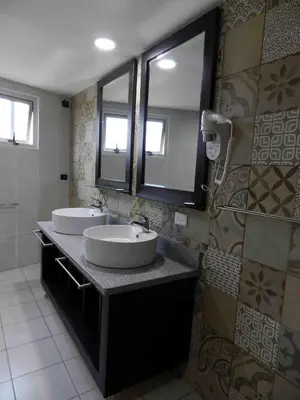 a bathroom with two sinks and a large mirror at MON Hotel Boutique in Constanza