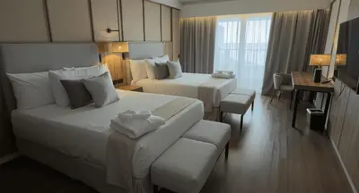a hotel room with two beds and a desk at Santo Domingo Bay Convention Resort & Casino in Boca Chica