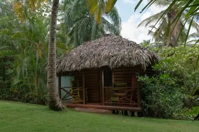 a small hut with a thatch roof and a table at Aventura Rincon Ecolodge in Las Galeras