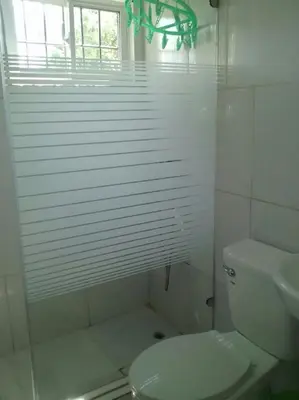 a white bathroom with a toilet and a sink at Casa Vasquez in San Felipe de Puerto Plata