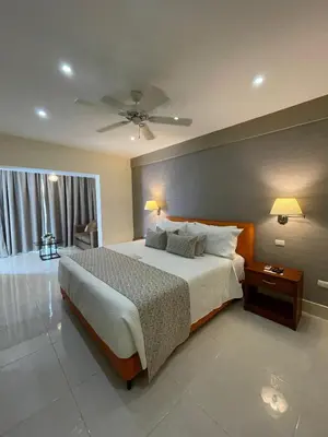 a bedroom with a large bed and a ceiling fan at Nilka Hotel Boutique in Santa Bárbara de Samaná
