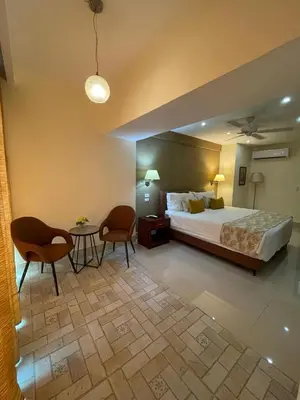 a hotel room with a bed and a table and chairs at Nilka Hotel Boutique in Santa Bárbara de Samaná
