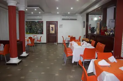 a dining room with tables and chairs and red columns at Gran Hotel Marien in Sabaneta