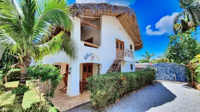 an exterior view of a house with a palm tree at Paradiso del Caribe in Las Galeras