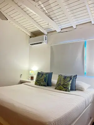 a bedroom with a large bed with blue pillows at Hotel Boutique Casa Grande By Playa Bonita in Las Terrenas