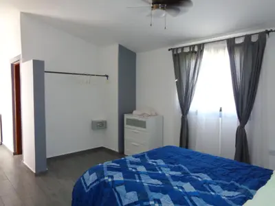 a bedroom with a blue bed and a window at La Cueva del Che in Juan Dolio
