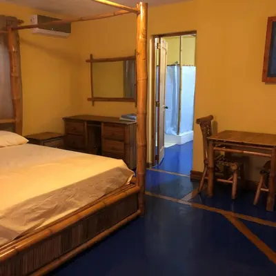 a bedroom with a bed and a desk and a mirror at La Cueva del Che in Juan Dolio