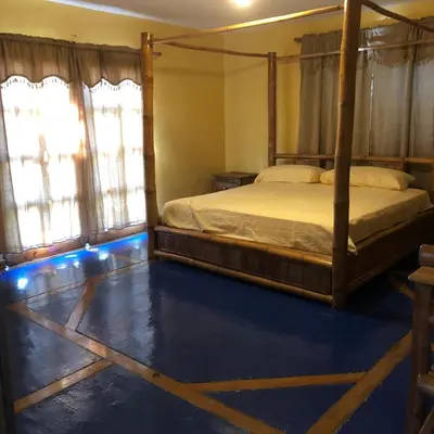 a bedroom with a bed and a blue floor at La Cueva del Che in Juan Dolio