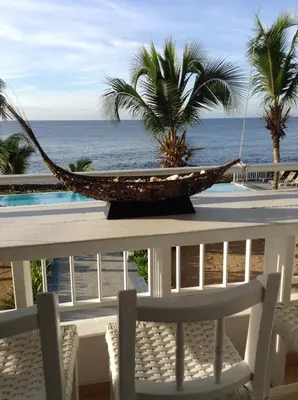 a hammock on a table with a view of the ocean at Apartamento Juan Dolio in Juan Dolio