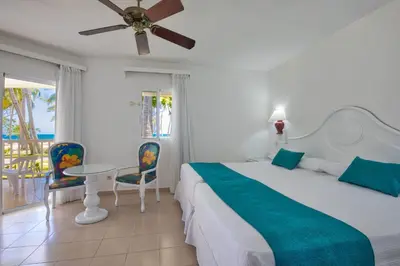 a bedroom with a bed and a table and chairs at Playabachata in San Felipe de Puerto Plata